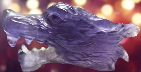 An amethyst dragon head on a purple background.