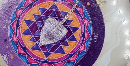 A necklace with a crystal and a tarot card on it in color