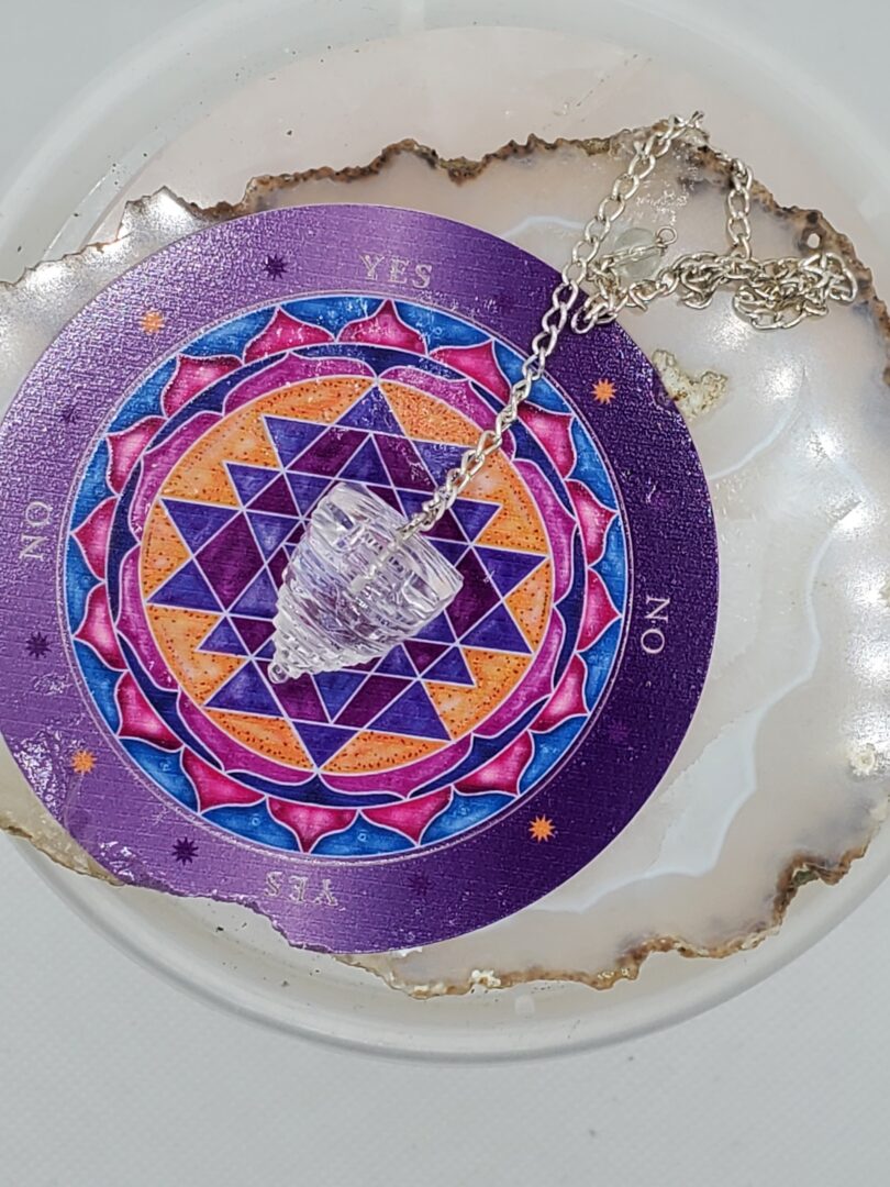 A necklace with a crystal and a tarot card on it in color